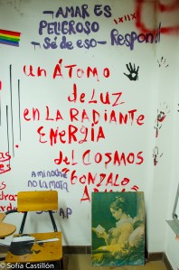 Escrito en la pared: "Un átomo de luz en la radiante energía del cosmos" de Gonzalo Arango. Arriba, escrito: "Amar es peligroso - sé de eso - respondí"